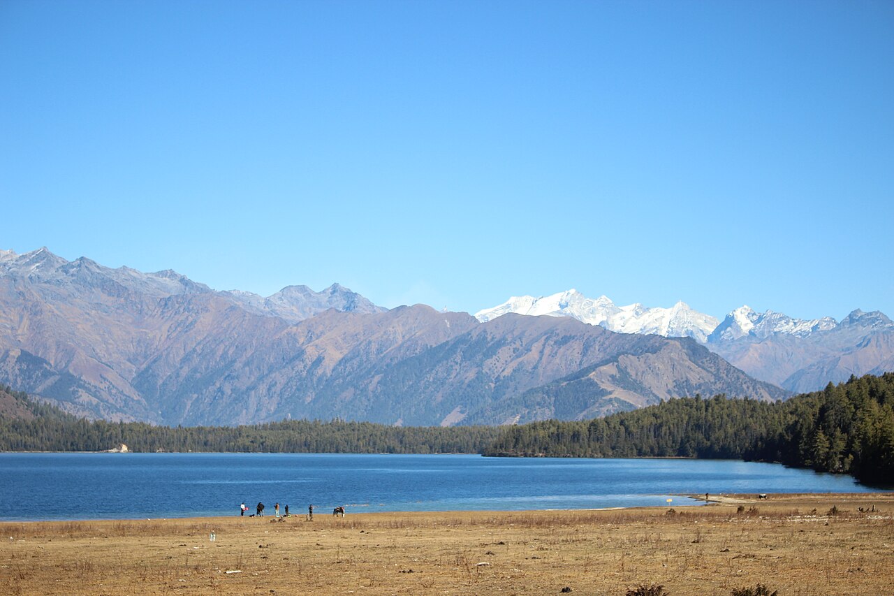 Rara Lake with forested hills and snow-capped mountains